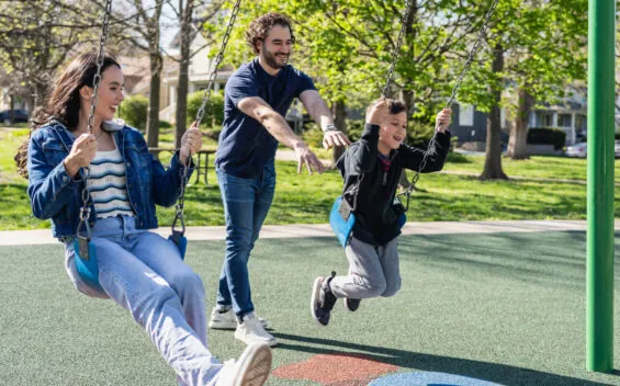 Young family enjoys a sunny day at a public playground in Kansas