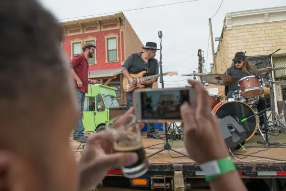 Close-up-of-man-taking-a-video-of-a-performer-on-an-outdoor-stage.