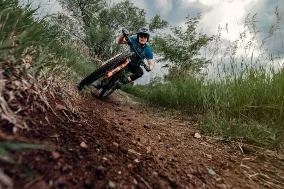 Man mountain biking down a dirt path on a cloudy day.